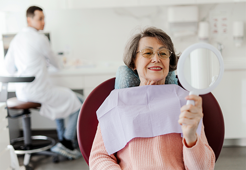 Senior woman looking at her smile in a mirror