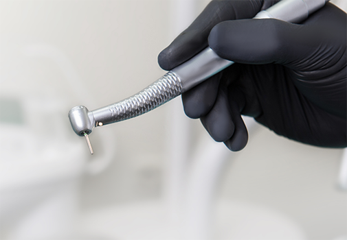 Dental professional holding a surgical drill