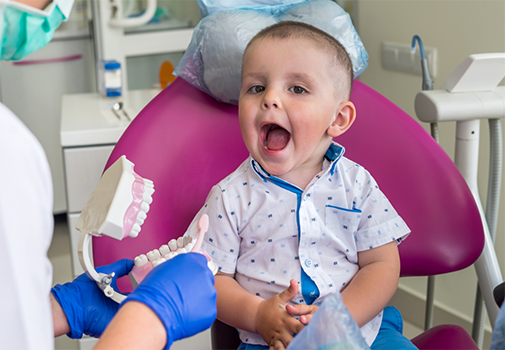 Child in the dental chair opening their mouth wide
