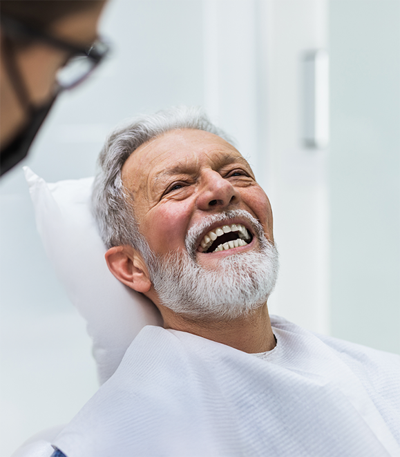 Senior man laughing while visiting his oral surgeon in Medford