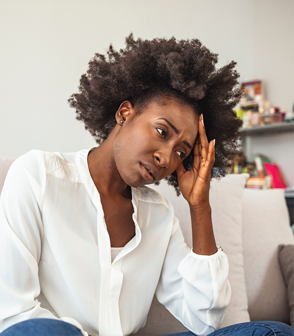 Woman touching her temple in pain before TMJ treatment in Medford