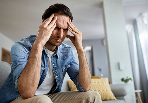 Man touching his temples in pain