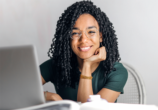 Smiling teenage girl at a desk with a laptop